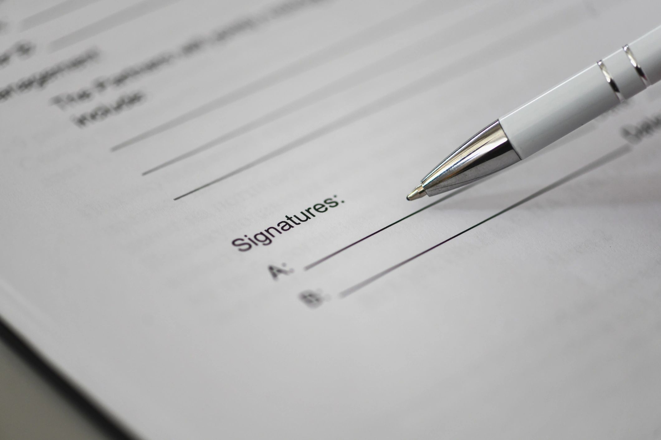 Pen signing paperwork on a desk